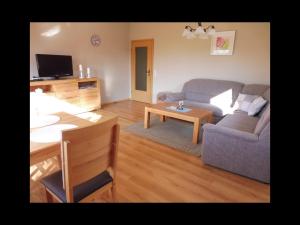 un soggiorno con un divano e un tavolo di Ferienwohnung Lüke a Wesselburener Deichhausen