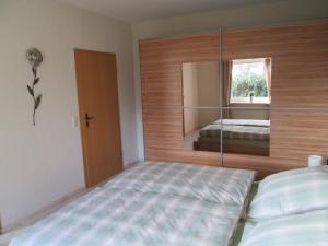 una camera da letto con un letto e uno specchio di Ferienwohnung Lüke a Wesselburener Deichhausen