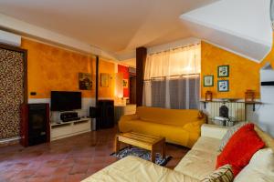 a living room with a yellow couch and a tv at Appartamento Sottosopra in Gallipoli