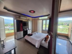 une chambre avec un lit et une grande fenêtre dans l'établissement HOTEL ROYAL Inn, à Trisūli Bāzār