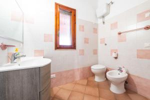 ein Bad mit einem Waschbecken, einem WC und einem Fenster in der Unterkunft Casa vacanza Mar Mediterraneo in Flumini di Quartu + 17 Fotos