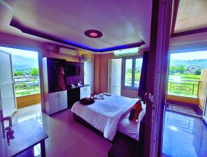 une chambre avec un lit dans une pièce avec des fenêtres dans l'établissement HOTEL ROYAL Inn, à Trisūli Bāzār