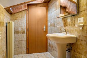 a bathroom with a sink and a wooden door at Samont Appartment 5 in Arabba +17 photos