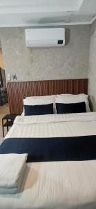 PampangにあるTownhouse Oak Grey Hotel Near Clark International Airportのベッドルーム1室(ベッド2台、青と白の枕付)