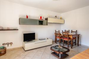 Una sala de estar con una mesa de comedor y un televisor. en Enza's Petite Maison, en Santa Croce sull'Arno