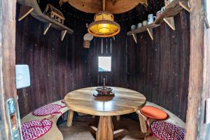 a wooden table and chairs in a room with a lamp at Stöcklhuberhof in Vandoies +16 photos