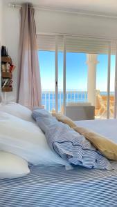 a bedroom with a bed with a view of the ocean at Jávea Beachfront Penthouse in Platja de l'Arenal +29 photos