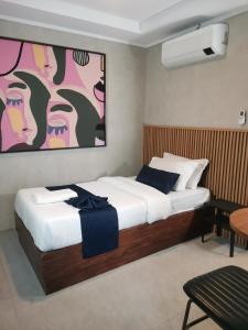 a bedroom with a bed with a painting on the wall at Townhouse Oak Grey Hotel Near Clark International Airport in Pampang