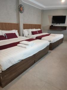 a bedroom with two beds and a flat screen tv at Townhouse Oak Grey Hotel Near Clark International Airport in Pampang