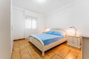a bedroom with a bed and a desk and a window at Appartamento a 10 minuti dal mare in Quartu SantʼElena