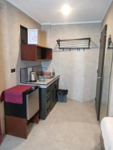 a small kitchen with a stove and a sink at Townhouse Oak Grey Hotel Near Clark International Airport in Pampang