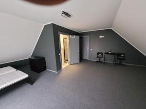 ein Dachzimmer mit einem Bett und einem Tisch und Stühlen in der Unterkunft Miķeļi in Īslīce