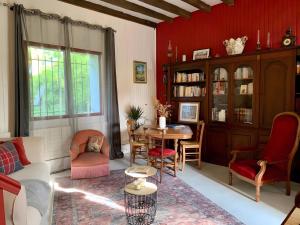 ein Wohnzimmer mit Tisch und Stühlen in der Unterkunft Gîte Du Petit Manoir De La Noue in Cornillé