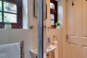 ein Badezimmer mit Waschbecken und Spiegel in der Unterkunft Stylish Victorian Terrace in Central Cambridge Pass the Keys in Cambridge + 40 Fotos