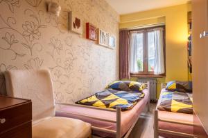 Una habitación con dos camas y una silla dentro. en Casa Heli 2 lake view, en San Zeno di Montagna