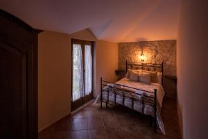 a bedroom with a bed with a stone wall at Spina Lake Rooms Matese in San Gregorio