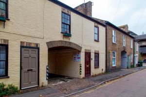 ein großes Backsteingebäude mit Garage auf einer Straße in der Unterkunft Stylish Victorian Terrace in Central Cambridge Pass the Keys in Cambridge