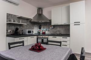 a kitchen with a table with a bowl of fruit on it at Villetta farfalle in Sarroch
