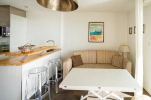 una sala de estar con un sofá y una mesa en 2 à 4p - Charmant studio vue Ocean, en Capbreton
