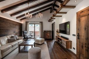 a living room with a couch and a tv at Residence Cesa Rives in Selva di Val Gardena