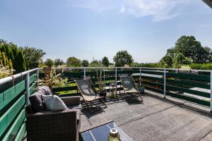 un patio con 2 sillas y una mesa en una valla en Watt´n Room, en Süderdeich