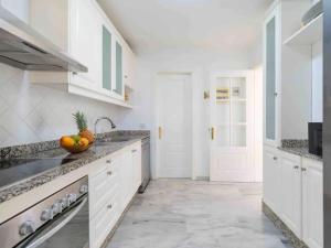 サン・バルトロメにあるVilla Lindaのキッチン(白いキャビネット付)、カウンターにフルーツを用意しています。