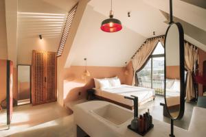 a bedroom with a bed and a sink and a mirror at The Aratana Villa in Da Lat