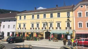a large yellow building with a cafe in front of it at Gh Alte Post - Top 6 Ascona in Gmünd in Kärnten