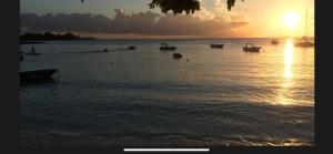 a group of boats in the water at sunset at Aqua Aura Pereybere in Grand Baie