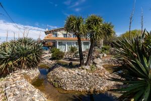 a house with palm trees in front of it at Gite complet à la Maison Mosaic in Gaillan-en-Médoc