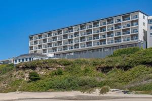 a building on top of a hill next to a beach at Elizabeth Oceanfront Suites, an Ascend Collection Hotel in Newport