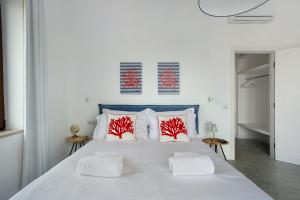 a bedroom with a large white bed with red pillows at Luxury Villa La Balena Blu in Massa Lubrense +31 photos