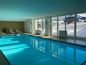 a swimming pool with blue water in a building at Ferienwohnung 109 Schwarzwald in Schönwald