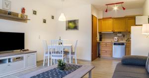 a living room with a table and a kitchen at Ferienwohnung 109 Schwarzwald in Schönwald
