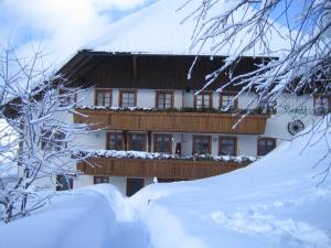 un bâtiment recouvert de neige avec un tas de neige dans l'établissement Ferienwohnung Otto Booz, à Schluchsee