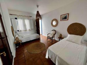 ein Schlafzimmer mit einem Bett und einem Stuhl darin in der Unterkunft Casa Rafa in Famara