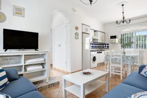 a living room with a blue couch and a table at Chalet Fuente3 piscina común famila in Conil de la Frontera