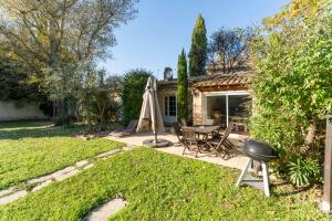 a patio with a table and a grill in a yard at La Rivière in Velleron