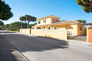 una casa amarilla con una valla blanca en una calle en Villa Germany, en Poblado de Sancti Petri