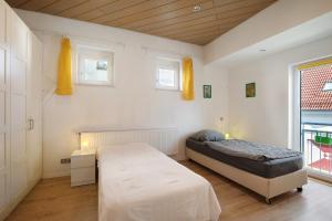 ニュルティンゲンにあるFerienwohnung Nürtingen Loft-Styleのベッドと2つの窓がある寝室