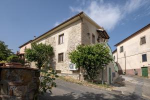 ソラーノにあるLa sosta del pellegrinoの木々が目の前に立つ古い石造りの建物