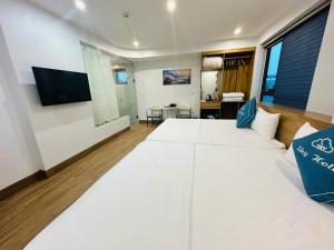 a bedroom with a large white bed and a tv at Sky Hotel in Ninh Binh