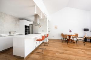a kitchen with white cabinets and a table with chairs at Apartamento Links Il in San Roque