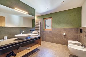 a bathroom with two sinks and two toilets at Huetterhof Apartement Langes in Caines +14 photos