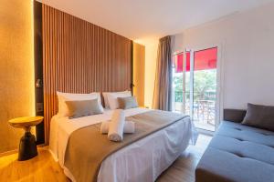 a bedroom with a large bed and a blue couch at Hostal Boutique - Rivolto Rooms in Santa Susanna
