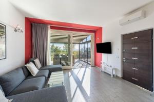 a living room with a couch and a tv at Residence Virgilio Red in Toscolano Maderno