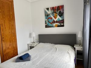 a bedroom with a white bed with a blue pillow on it at Villa Capricho in Mazarrón +25 photos