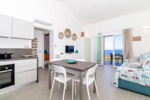 トリニタ・ダグルトゥにあるCarolina Houseのテーブルと椅子のあるキッチンとリビングルーム