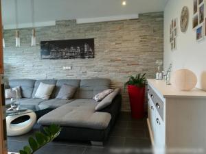 プレッテンベルクにあるFerienwohnung am Silbergのソファとレンガの壁のあるリビングルーム