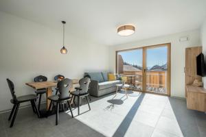 Una sala de estar con un sofá, una mesa y sillas. en Sunnig Apartment Abendsonne, en Foiana - Völlan
